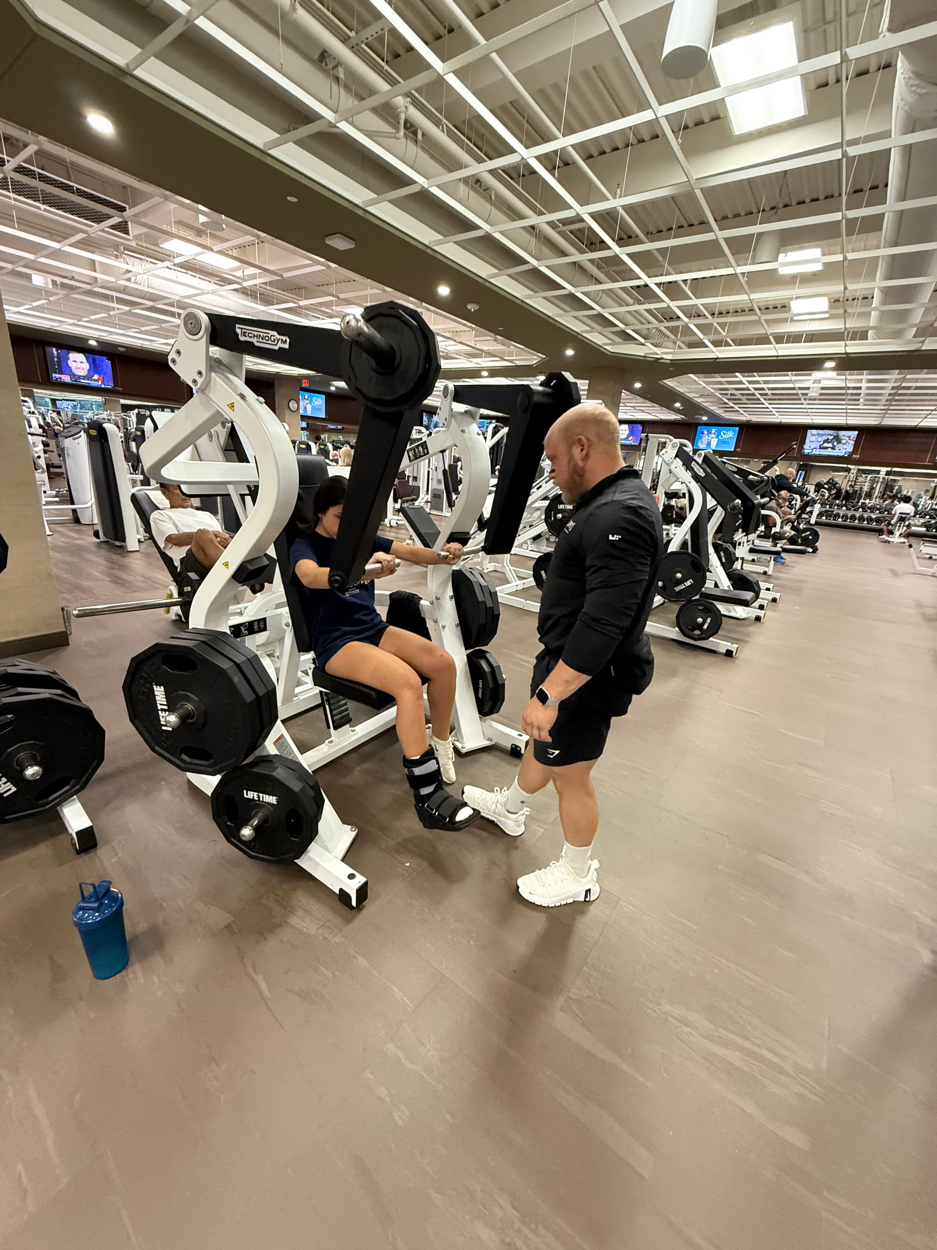 Coaching a client on a machine in the gym